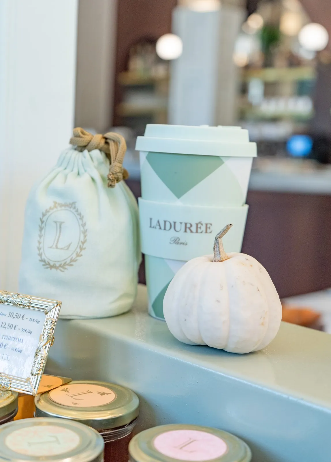 Pochon Ladurée, gobelet et petite citrouille sur le comptoir